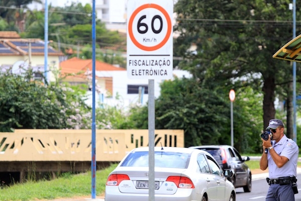 Policial militar maneja aparelho em avenida da cidade